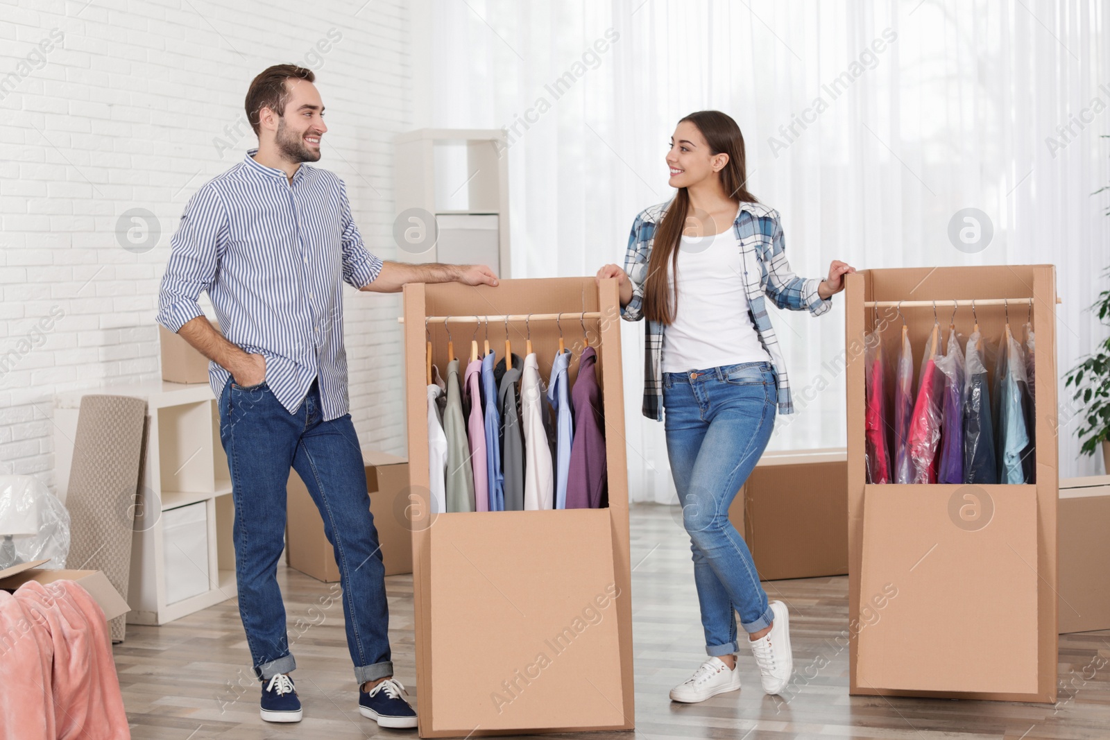 Photo of Young couple near wardrobe boxes at home