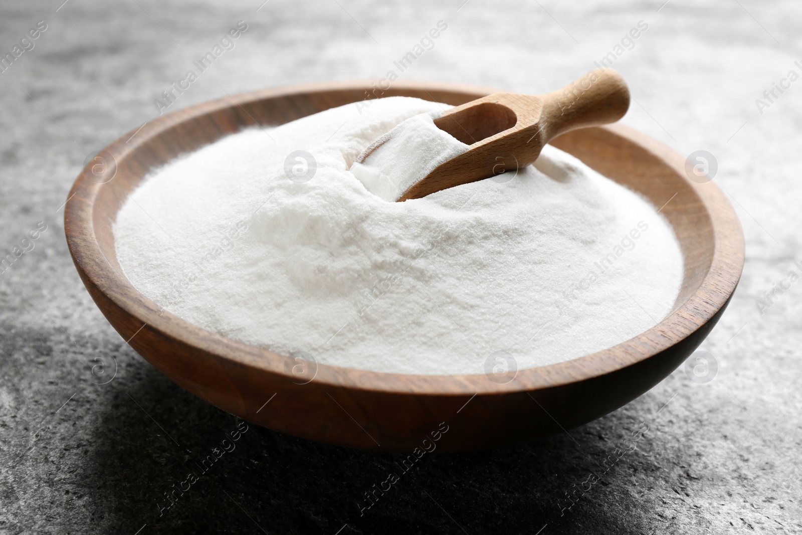 Photo of Baking soda in bowl on grey table