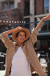 Portrait of happy young woman on city street