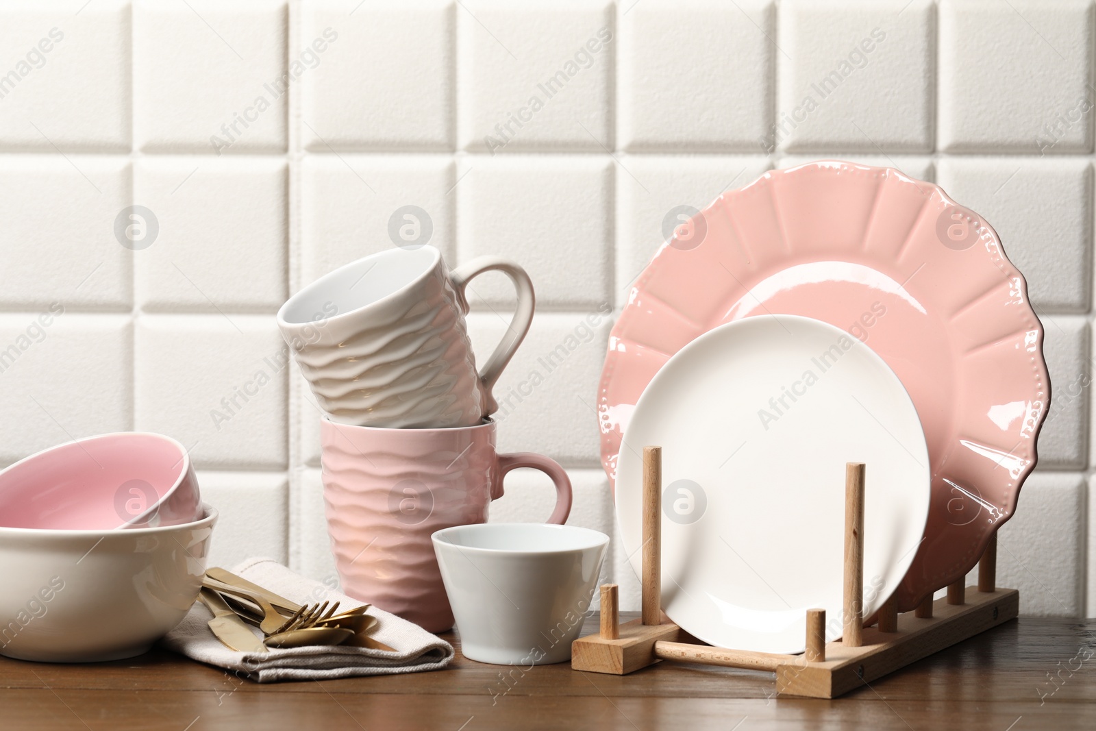 Photo of Beautiful ceramic dishware, cups and cutlery on wooden table