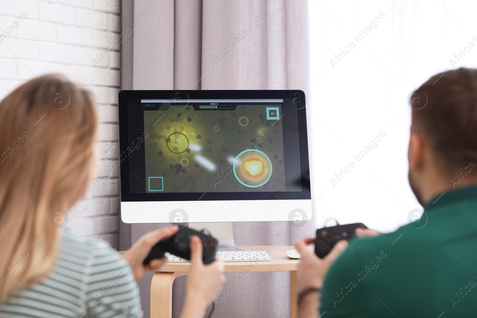 Photo of Young couple playing video game at home