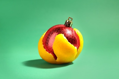 Christmas ball in tangerine zest on green background