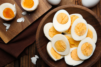 Photo of Tasty boiled chicken eggs on wooden table, flat lay