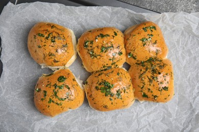 Photo of Traditional pampushka buns with garlic and herbs on baking dish, top view