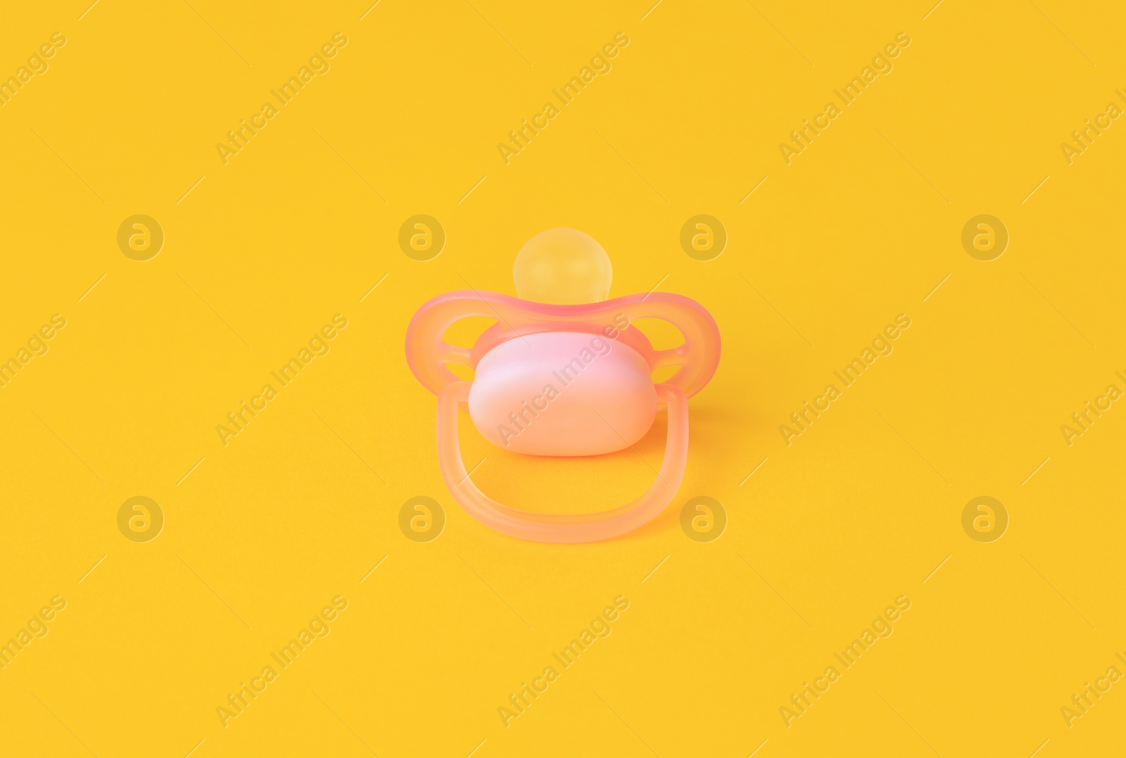 Photo of One new baby pacifier on orange background