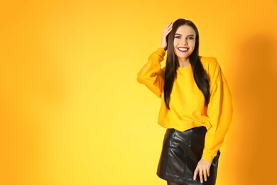 Photo of Beautiful young woman posing on yellow background, space for text. Halloween party