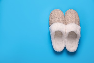 Photo of Pair of beautiful soft slippers on light blue background, top view. Space for text