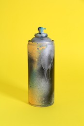 One spray paint can on yellow background