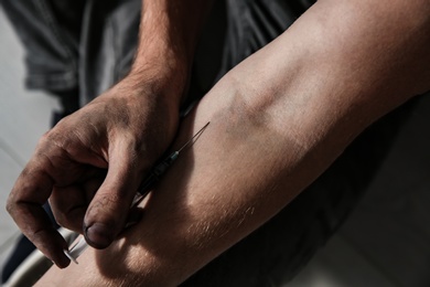 Photo of Male drug addict making injection, focus on hands