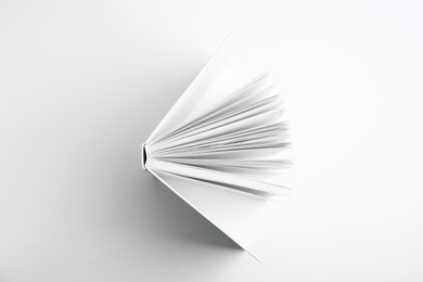 Photo of Open book with hard cover on white background, top view