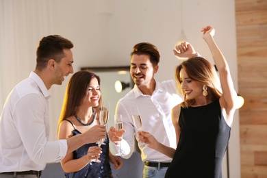 Photo of Happy friends with champagne in glasses having party indoors