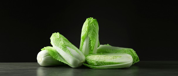 Image of Fresh ripe Chinese cabbages on grey table against black background, banner design