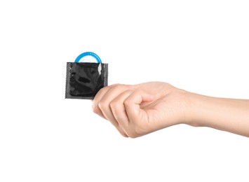 Woman holding condom in wrapper on white background, closeup