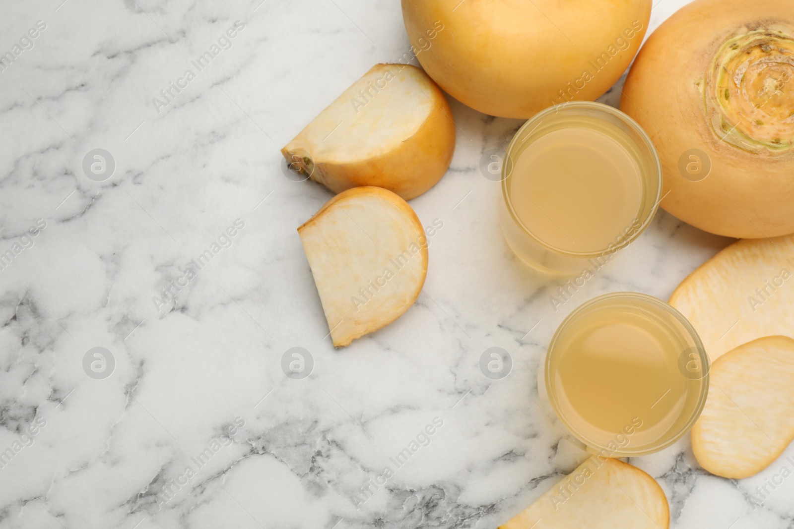 Photo of Freshly made turnip juice on white marble table, flat lay. Space for text