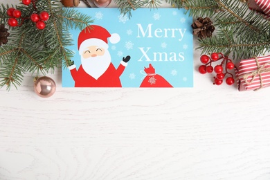 Photo of Flat lay composition with Christmas card and festive decor on white wooden background, space for text