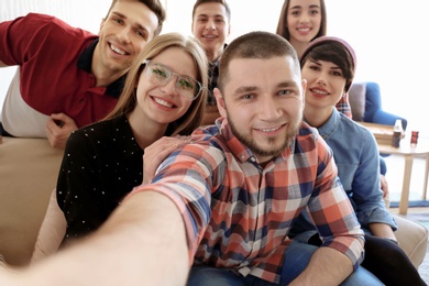 Happy friends taking selfie indoors