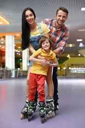 Happy family spending time at roller skating rink