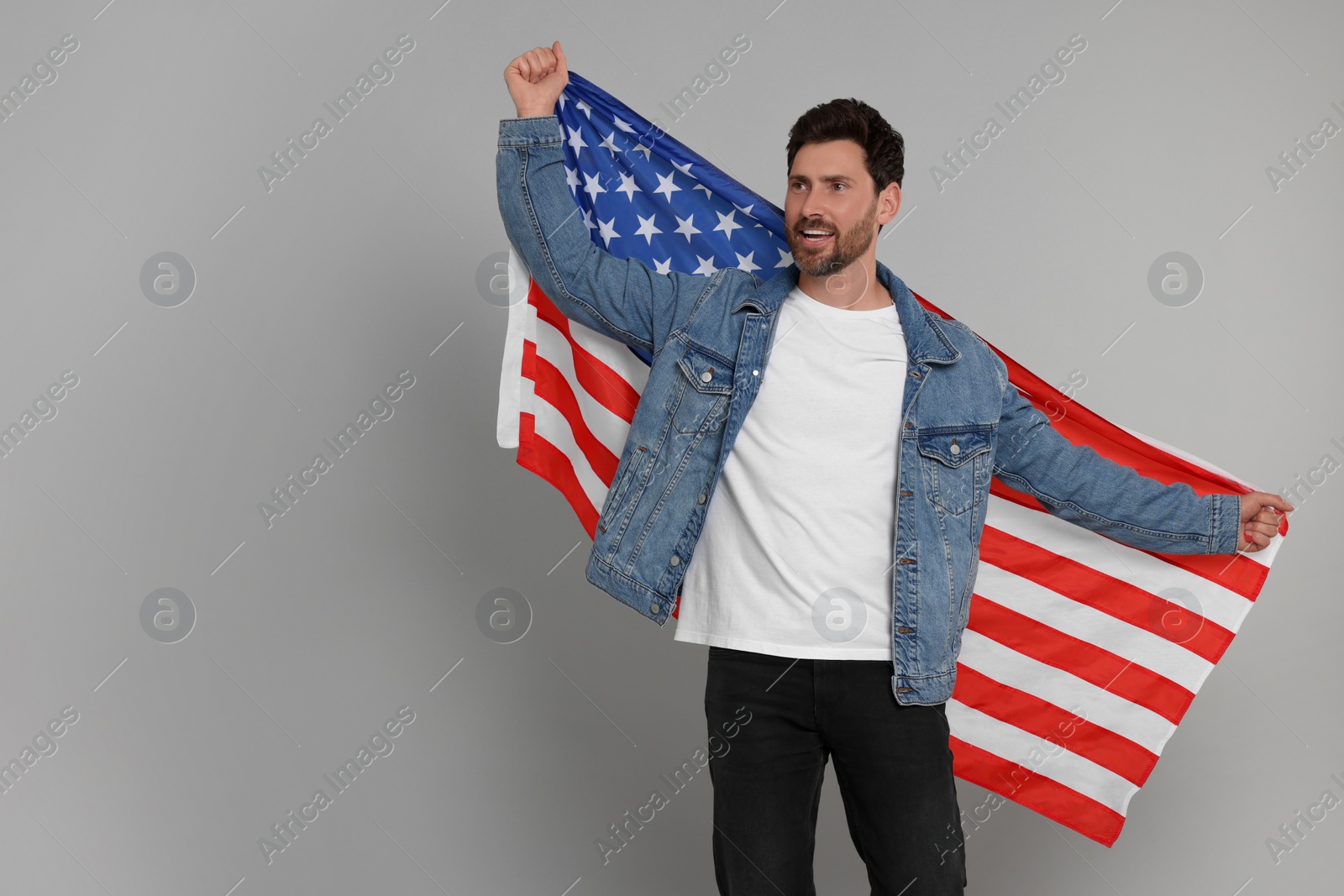 Photo of 4th of July - Independence Day of USA. Happy man with American flag on grey background