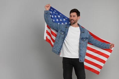 4th of July - Independence Day of USA. Happy man with American flag on grey background
