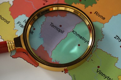 Photo of Golden magnifying glass above Ternopil and Khmelnytskyi regions on map of Ukraine, closeup