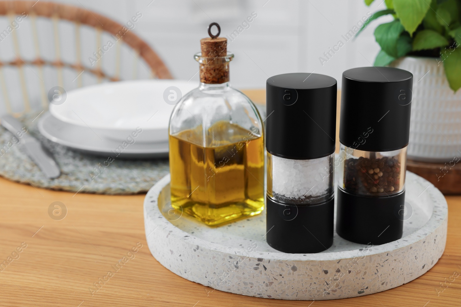 Photo of Salt and pepper shakers and bottle of oil on wooden table, space for text