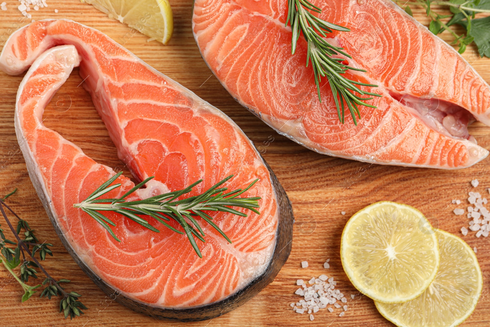 Photo of Fresh salmon and ingredients for marinade on wooden board, flat lay