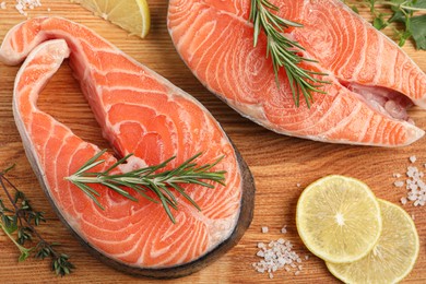 Photo of Fresh salmon and ingredients for marinade on wooden board, flat lay