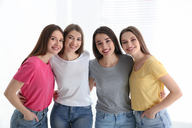 Photo of Beautiful young ladies in jeans and colorful t-shirts indoors. Woman's Day