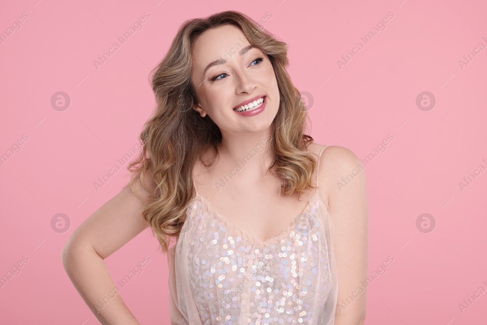 Photo of Portrait of smiling woman on pink background