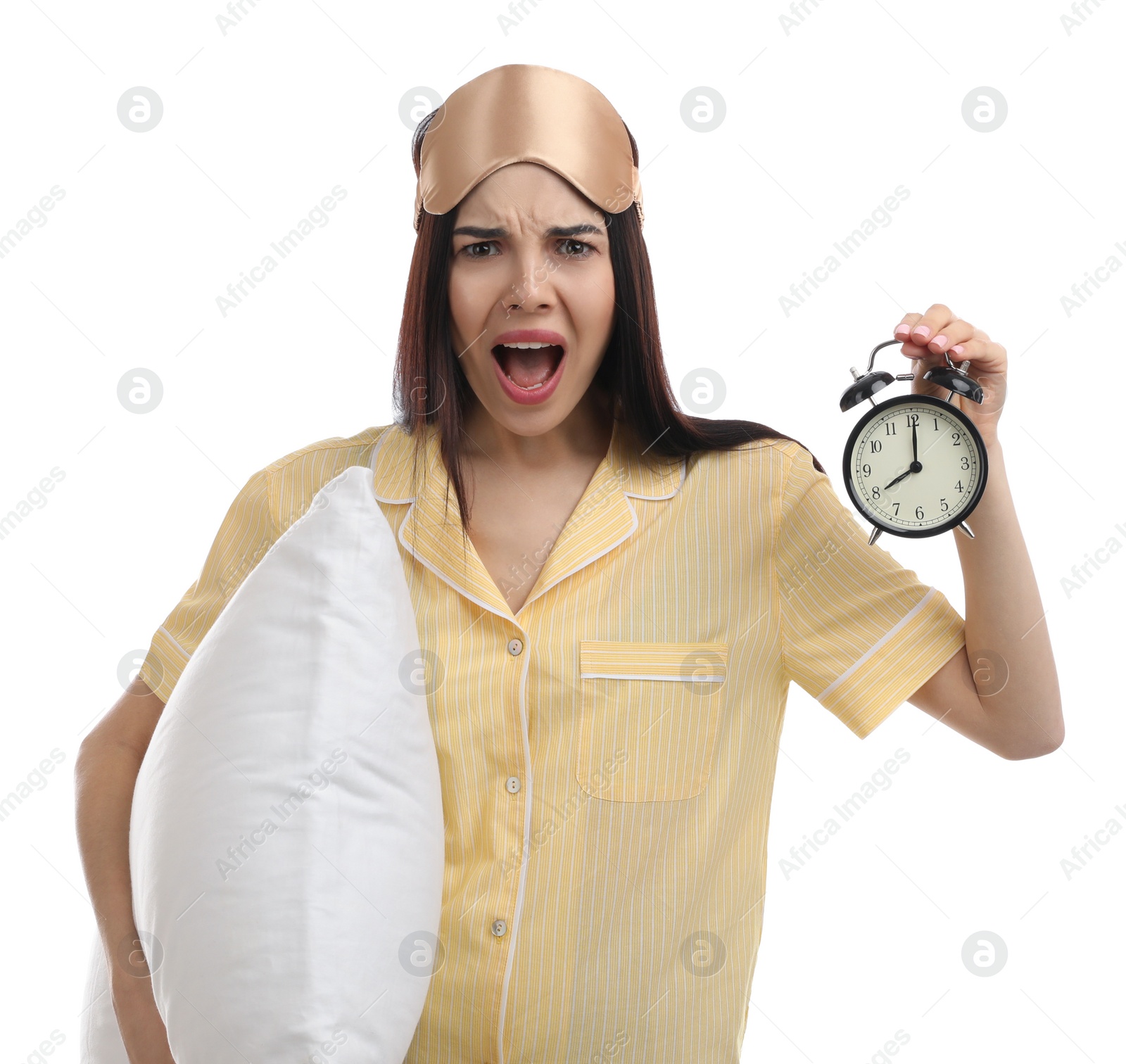 Photo of Emotional overslept woman with alarm clock and pillow on white background. Being late concept