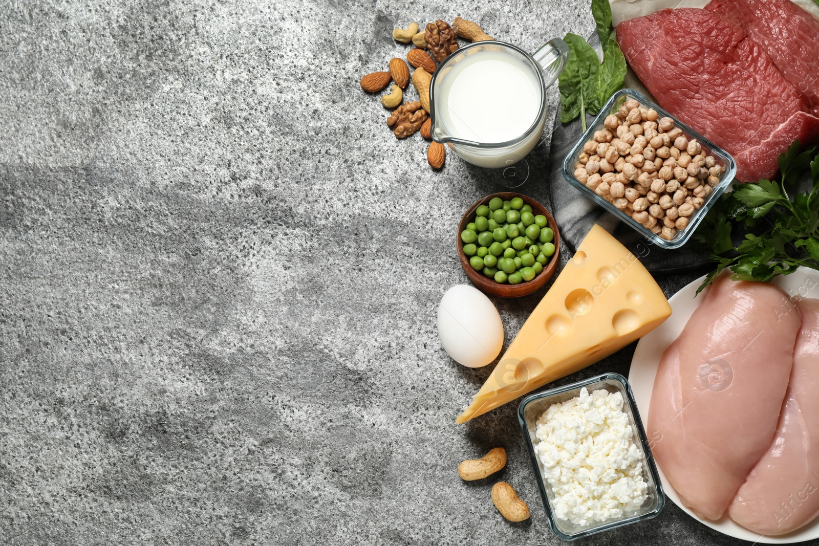 Photo of Products rich in protein on grey table, flat lay. Space for text