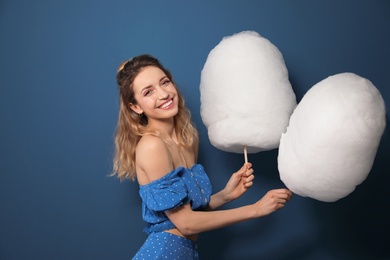 Photo of Portrait of pretty young woman with cotton candy on blue background