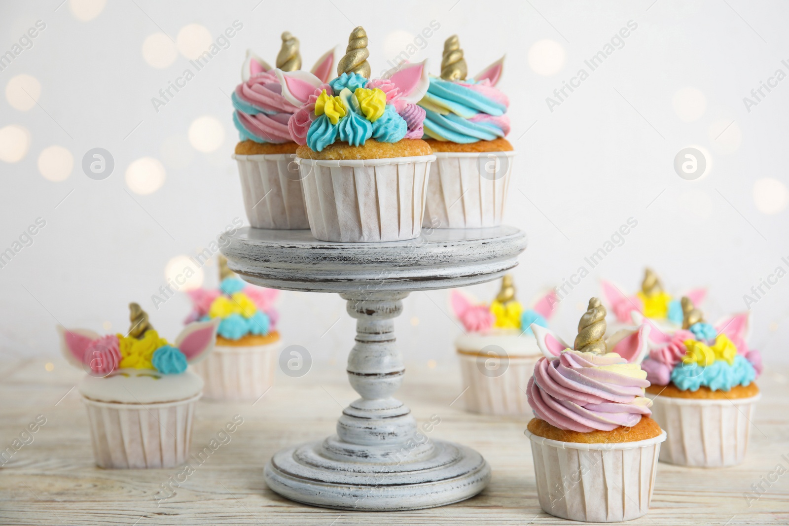 Photo of Cute sweet unicorn cupcakes on white wooden table