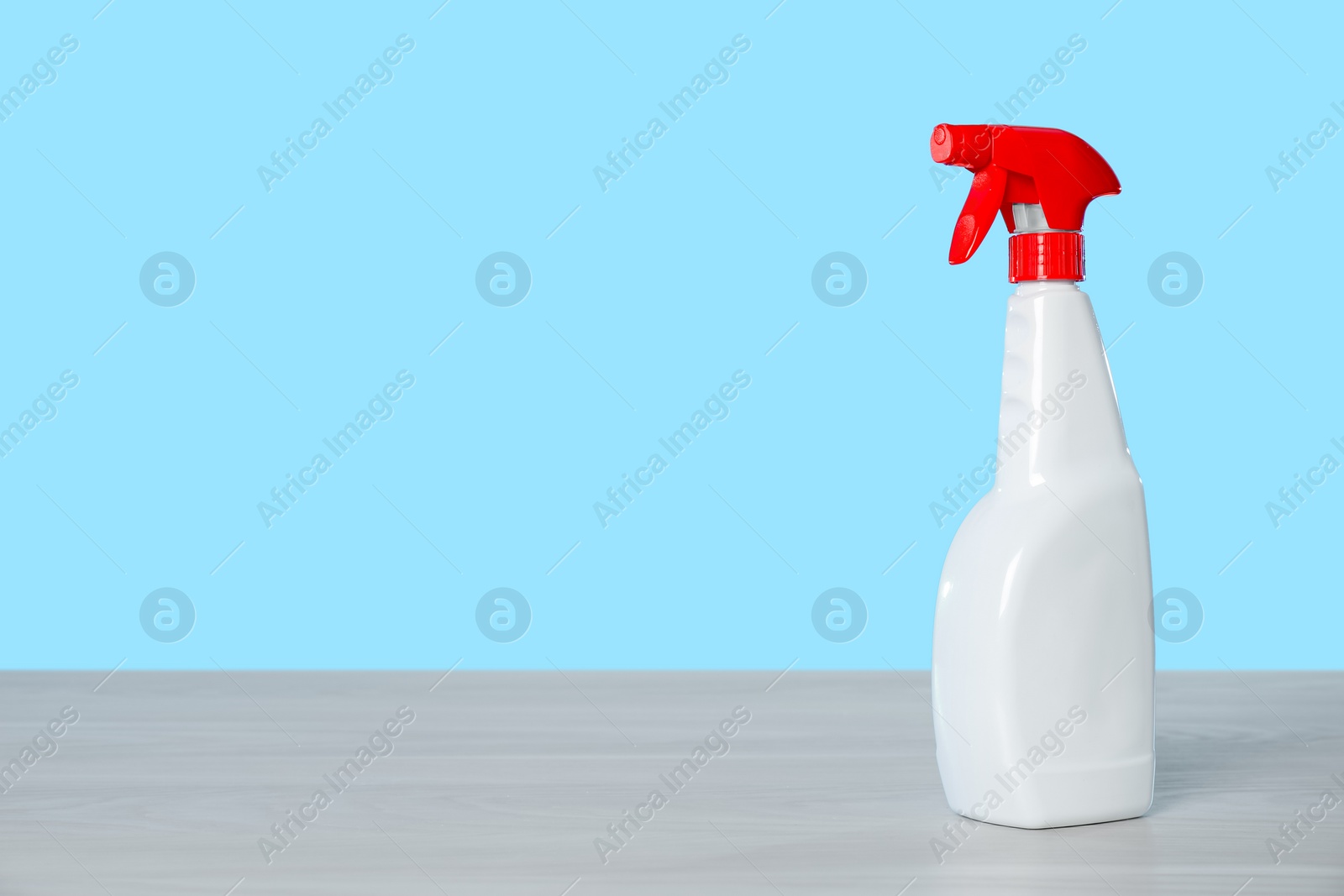 Photo of Bottle of cleaning product on light table. Space for text