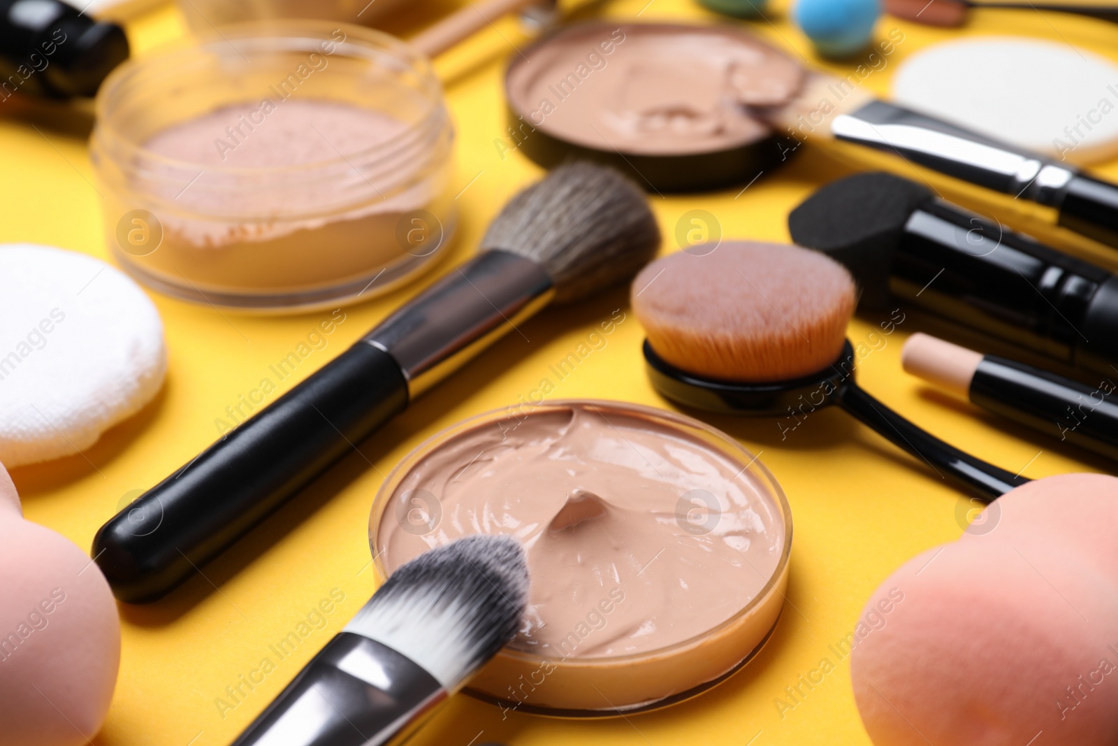 Photo of Composition with skin foundation and beauty accessories on color background