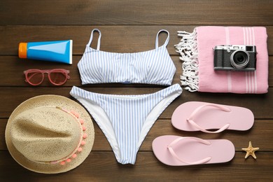 Different beach objects on wooden background, flat lay