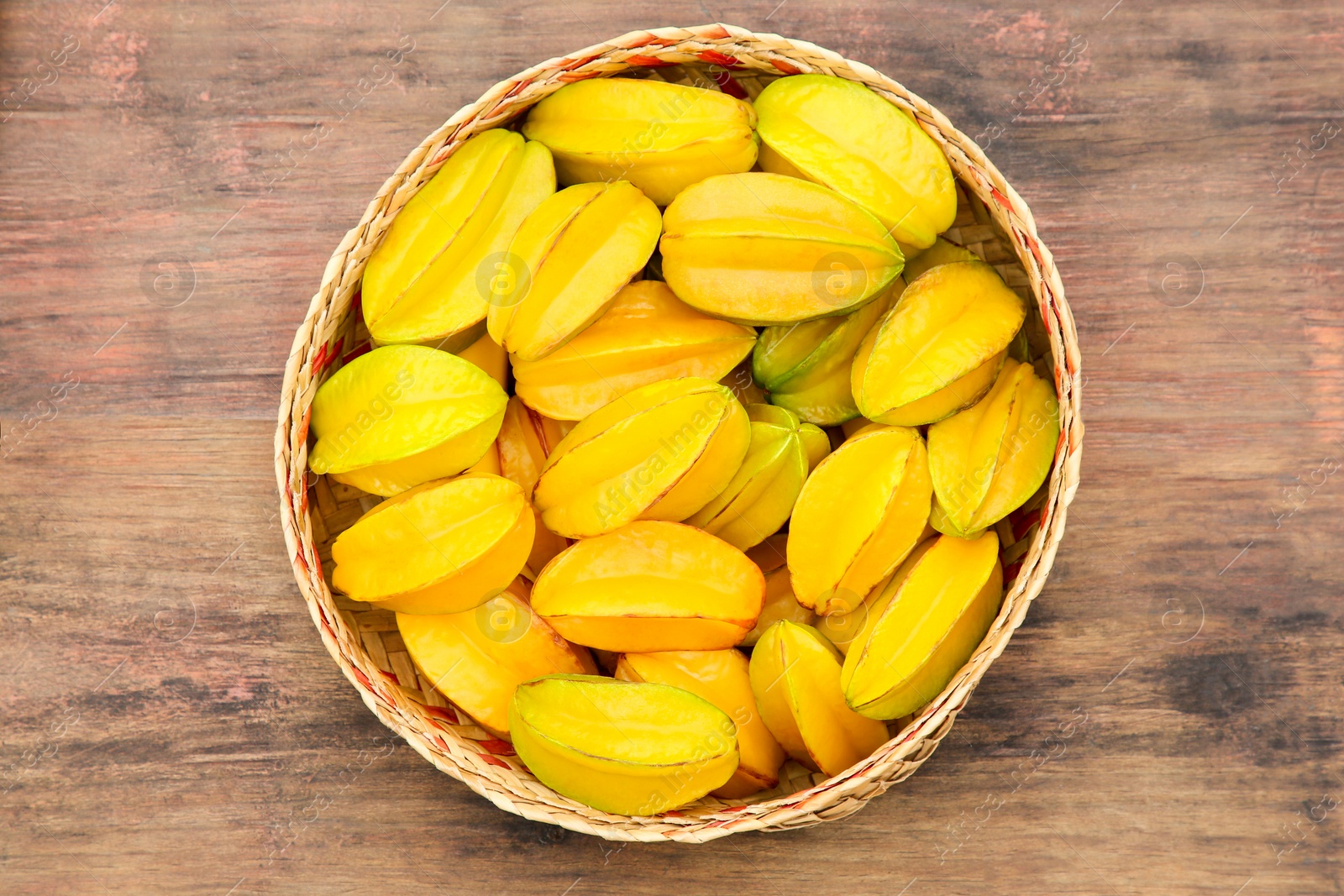 Photo of Delicious ripe carambolas on wooden table, top view