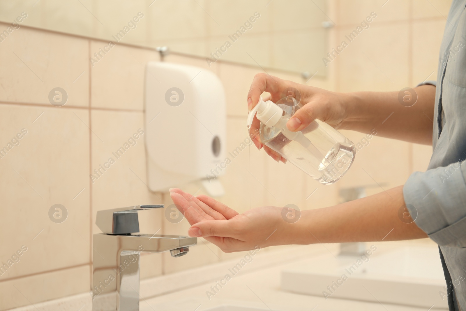 Photo of Woman applying antiseptic soap onto hand in bathroom, closeup. Virus prevention