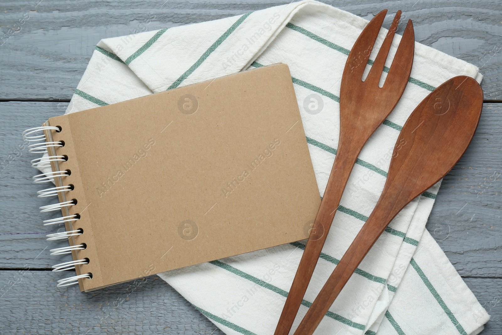 Photo of Blank recipe book and kitchen utensils on grey wooden table, flat lay. Space for text
