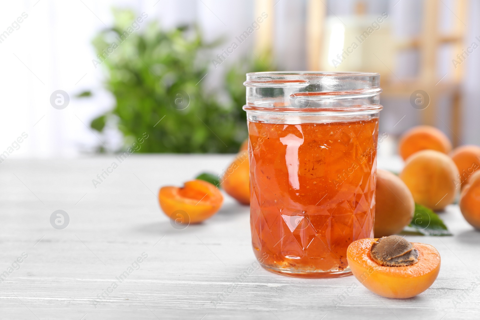 Photo of Jar with tasty apricot jam on table