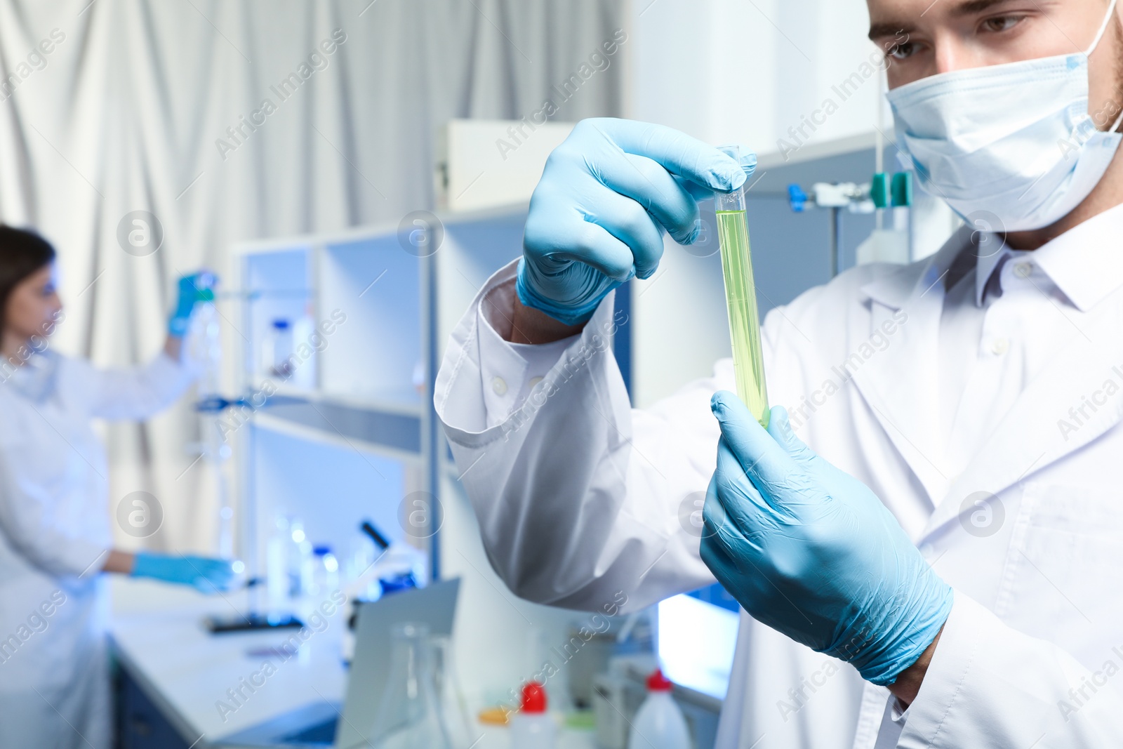 Photo of Scientist holding test tube with liquid indoors, closeup. Laboratory analysis