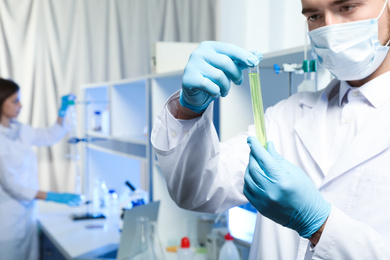 Scientist holding test tube with liquid indoors, closeup. Laboratory analysis