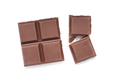 Photo of Pieces of delicious milk chocolate bars on white background, top view