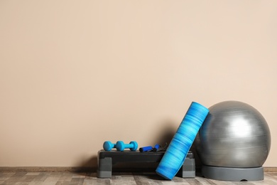 Photo of Set of fitness inventory on floor near color wall. Space for text