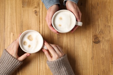 Photo of Women having coffee break at wooden table, top view