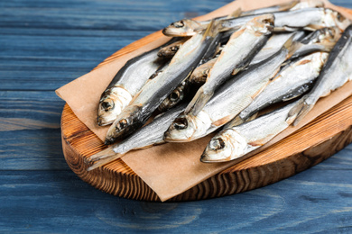 Tasty dried fish on blue wooden table