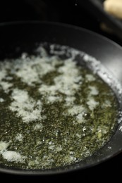 Photo of Melting butter in frying pan on table, closeup