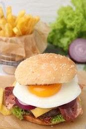 Photo of Delicious burger with fried egg on table, closeup. Space for text