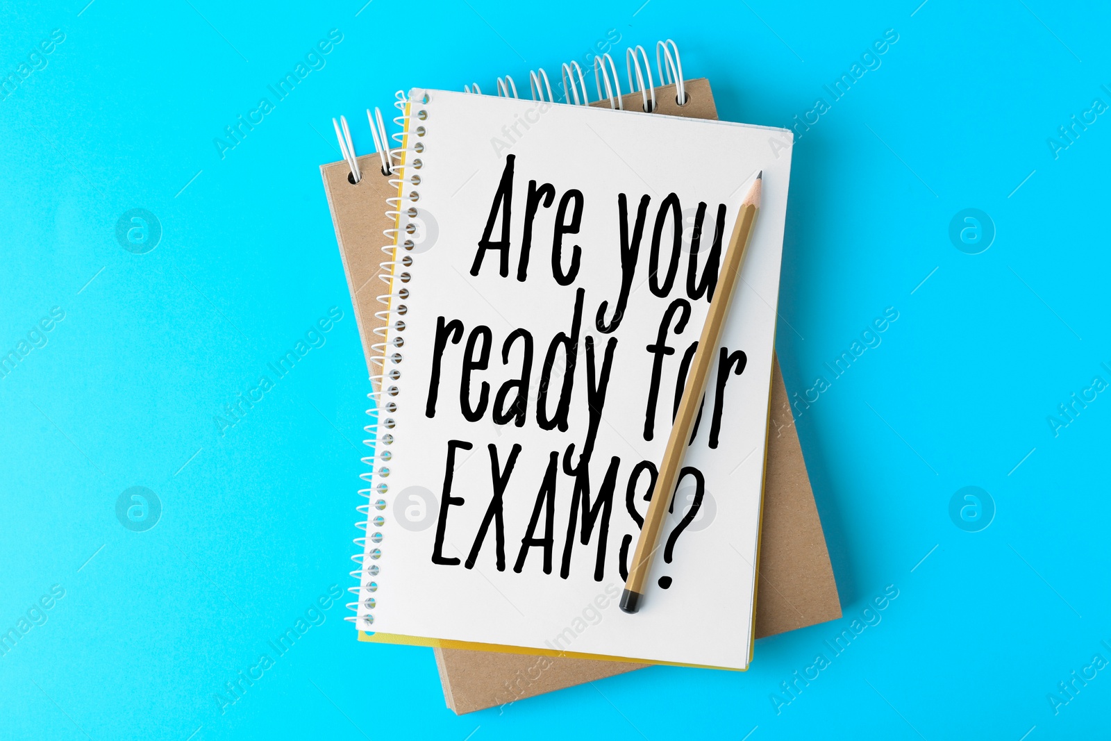 Image of Notebooks with phrase ARE YOU READY FOR EXAMS and pencil on light blue background, top view