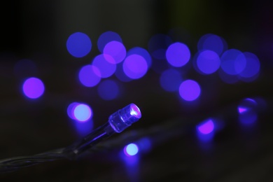 Blue Christmas lights on dark background, closeup view